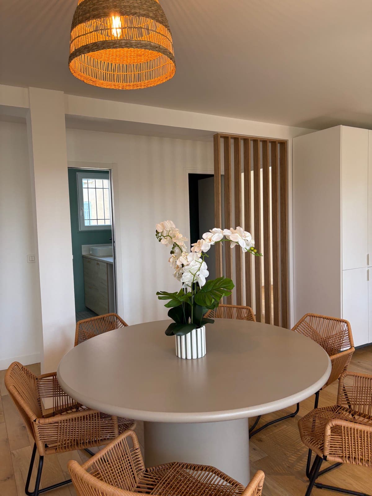 Table ronde et chaises en rotin, devant le claustra en tasseaux de bois — Sanary-sur-Mer — deux appartements meublés