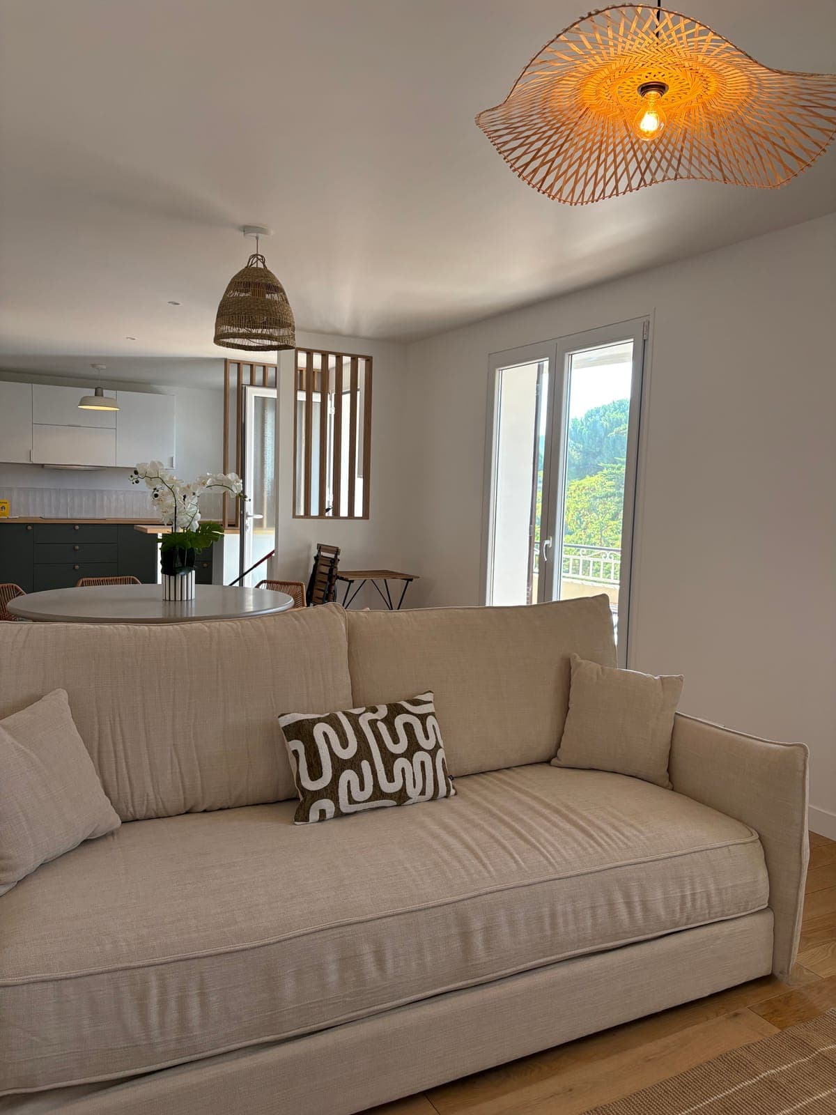 Salon en lin naturel avec coussin à motifs et suspension en rotin, Sanary-sur-Mer